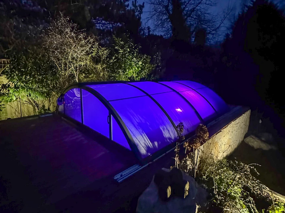 Scène extérieure en pleine nature avec ampoule LED blanche plantée dans terre brune aux côtés d'une jeune pousse verte à deux feuilles
