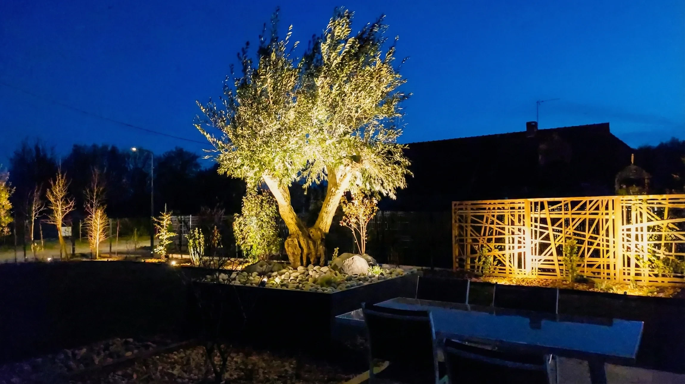 Terrasse extérieure avec spa jacuzzi illuminé de LED bleues au crépuscule