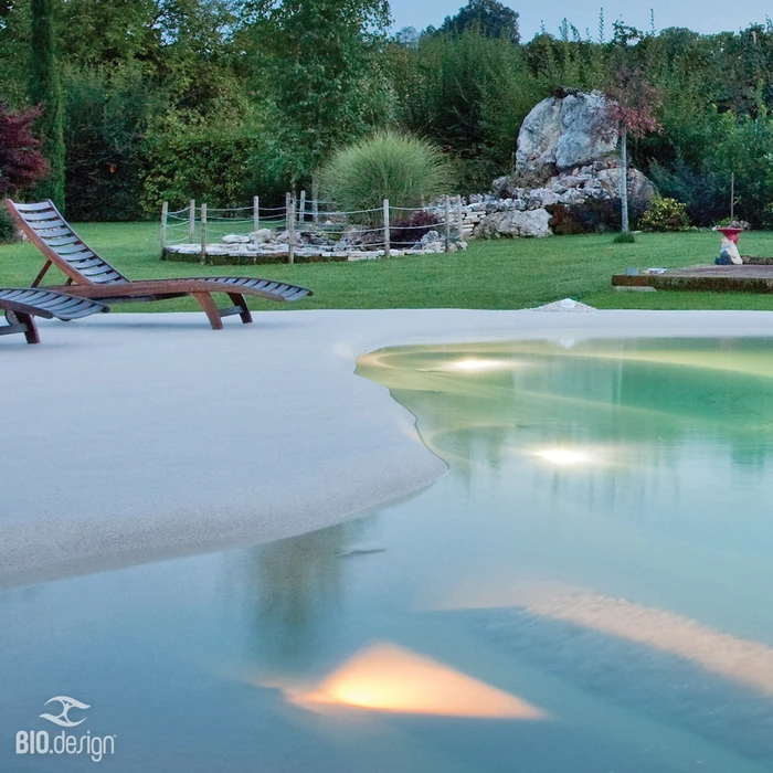 Bassin d'ornement extérieur avec fontaine à jet d'eau central, poissons rouges nageant dans l'eau claire