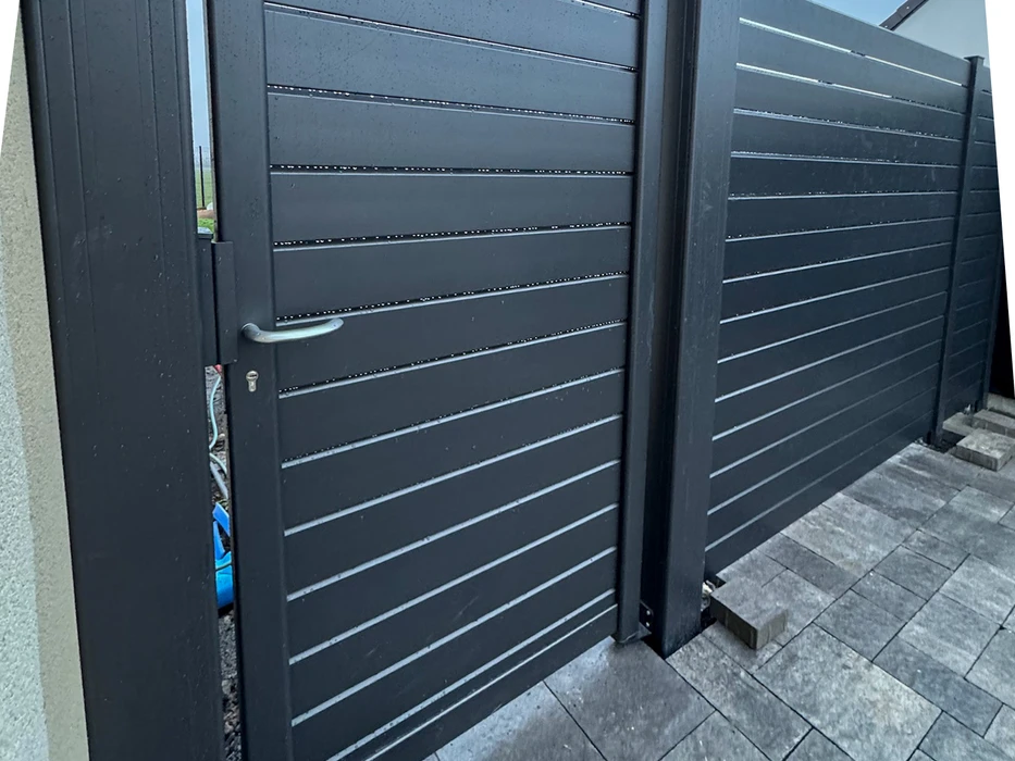 Scène extérieure résidentielle avec portail et clôture gris anthracite en aluminium laqué