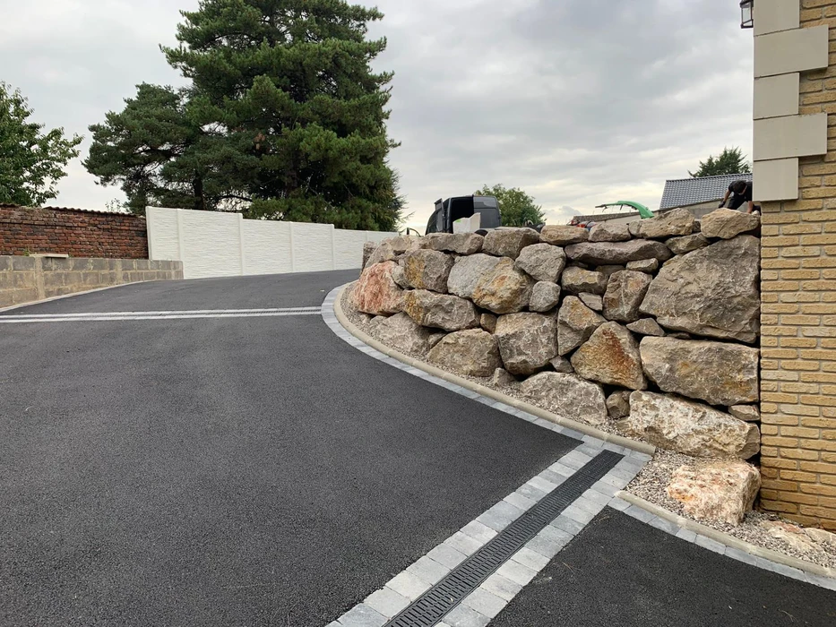 Jardin paysager avec allée en dalles de pierre naturelle traversant pelouse soignée