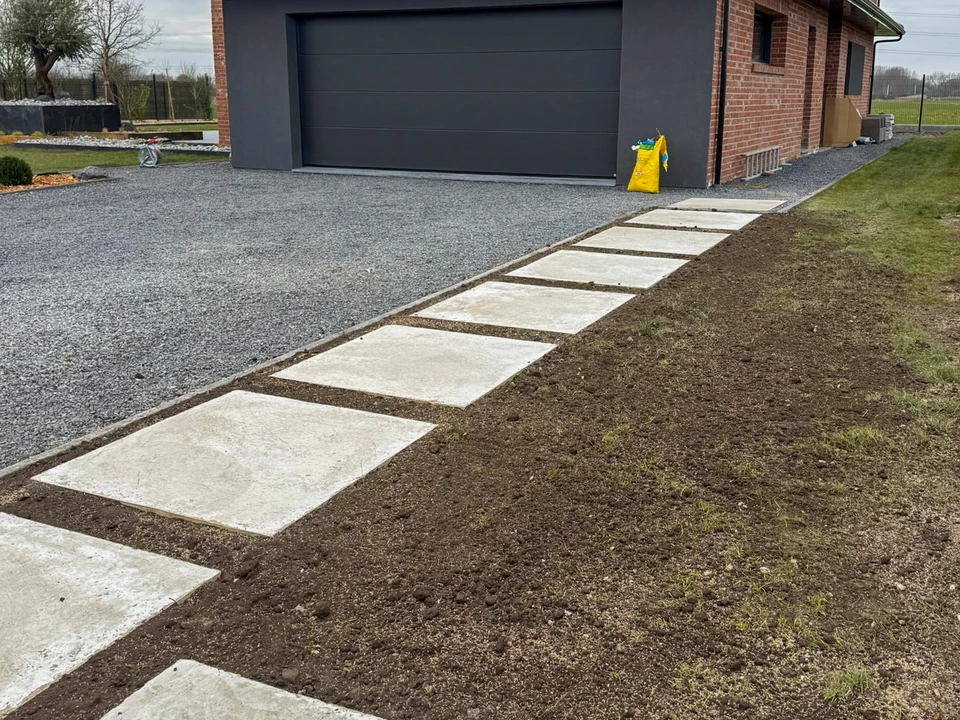 Chantier extérieur de pose de pavés par un ouvrier en tenue de travail