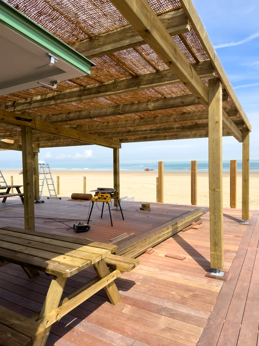 Terrasse extérieure couverte d'une pergola en bois avec salon de jardin contemporain