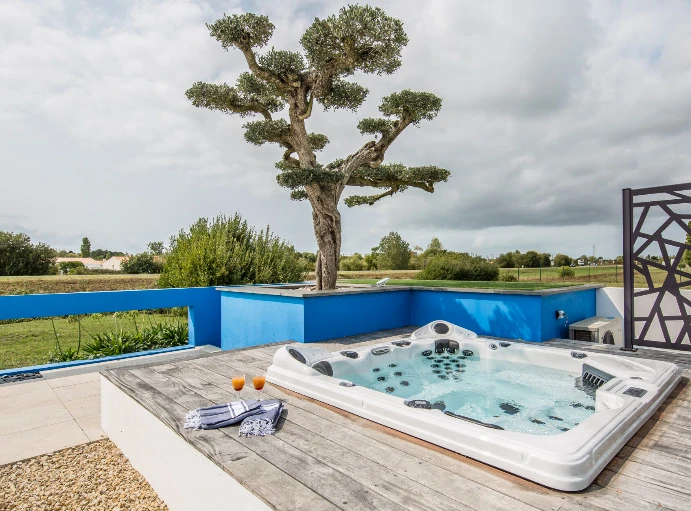Un joli petit jardin urbain à l'arrière-cour avec patio pavé tumultueux, des pierres de pas de pierre de taille et une variété d'arbres, d'arbustes et de plantes vivaces ajoutent de la couleur et de l'intérêt toute l'année