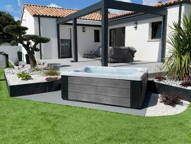 Piscine ext&eacute;rieure avec spa int&eacute;gr&eacute; dans jardin paysager r&eacute;sidentiel